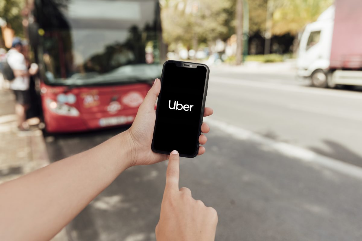 close up finger pointing phone screen Uber Stock Price Drops Despite Reporting Its Best Quarter Ever