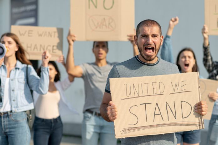 people marching together protest e1698689893967 GM Strikes Preliminary Deal with UAW, Following in the Footsteps of Ford and Stellantis